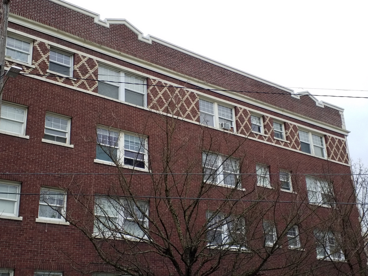 Photo taken Feb. 2018. View of the upper three floors at the south side of the west end of the Empress Apartments Hotel.  Built in 1926 at 16th and Washington.  Current Address in 2017 is 1539-1541 W Burnside. Order #165 Glaze #22M in Leonard Martins order book for Columbia Terra Cotta Co.  The name of the hotel was for a period of time "Marquette Manor"